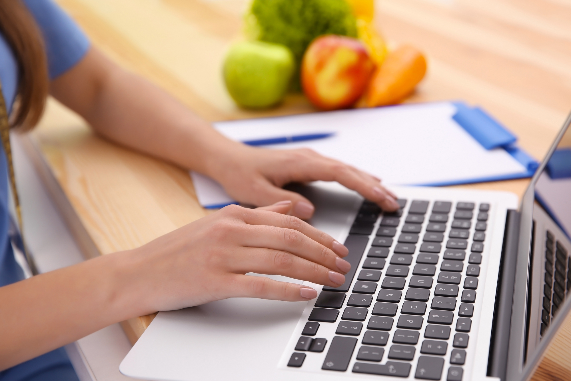 Young female nutritionist working with laptop in office, closeup Young female nutritionist working with laptop in office, closeup